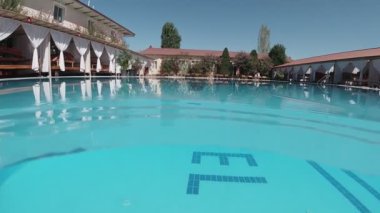 Mavi kiremitlerle süslenmiş açık havuzun sualtı çekimi..