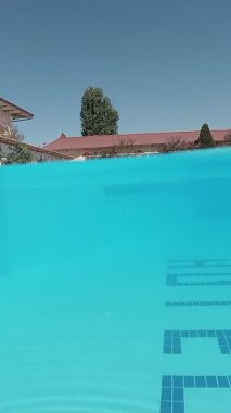 Mavi kiremitlerle süslenmiş açık havuzun sualtı çekimi..