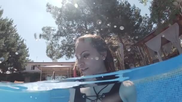 수영복을 망토를 여자가 파란색 타일로 장식된 수영장 바닥에 — 비디오