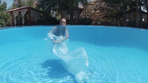 Junge Frau Schwarzem Badeanzug Und Weißem Umhang Schwimmt Mit Blauen — Stockvideo