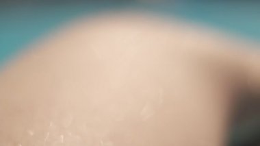 Genç bir kadının cildindeki su damlalarına aşırı yakın çekim. Yavaş çekim