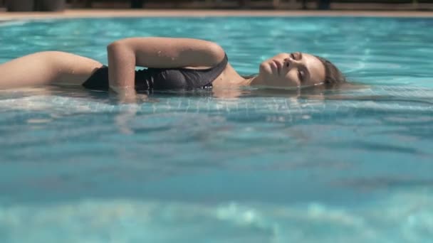 Açık Havuzda Siyah Mayo Şeffaf Pelerin Giyen Genç Bir Kadın — Stok video