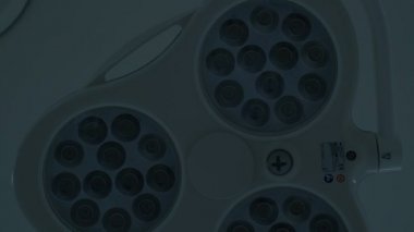 Ameliyat masasının üstündeki ışıklar kapalı, aşağıdan görüş, yavaş çekim