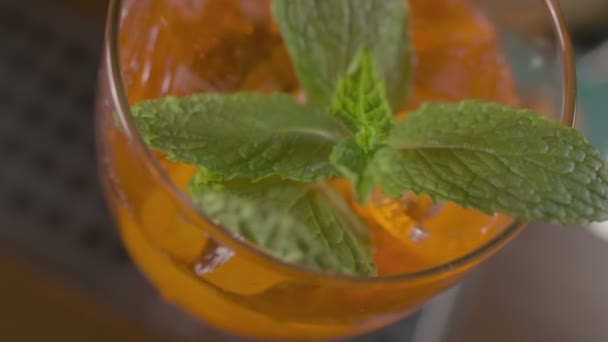 Primer Plano Cóctel Naranja Con Hojas Menta Hielo Vaso Cámara — Vídeos de Stock