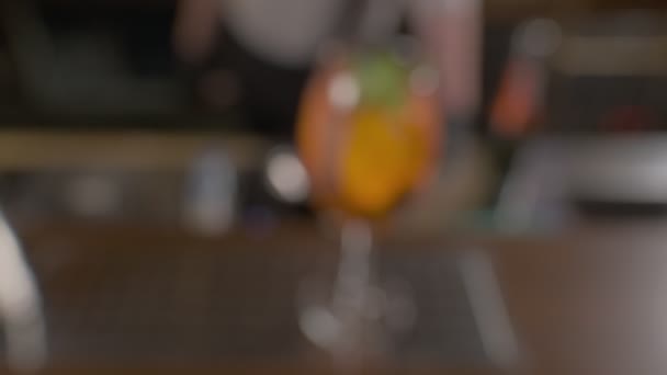 薄荷叶和玻璃杯中冰块的橙色鸡尾酒 慢动作 — 图库视频影像