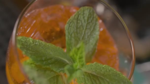 Nahaufnahme Eines Orangefarbenen Cocktails Mit Minzblättern Und Eis Glas Zeitlupe — Stockvideo
