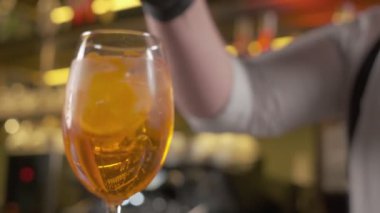 Barmen bardağa nane yaprakları koyar.