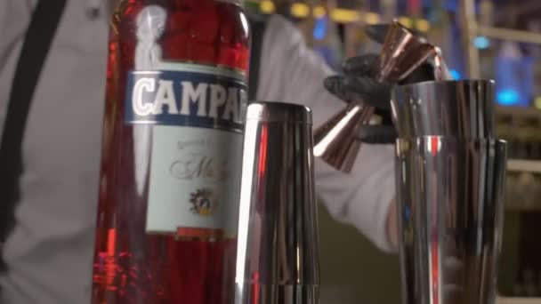 Barmen Memakai Sarung Tangan Hitam Menempatkan Campari Dari Jigger Shaker — Stok Video