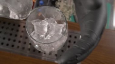 Şişeden kokteyl bardağına kadar ağır çekim, buzla doldurulmuş Campari.