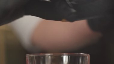 Kokteylin içine portakal kabuğu koymaya yakın çekim, yavaş çekim.