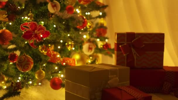 クリスマスツリーの下にギフトボックスを置くサンタの手の閉鎖 スローモーション — ストック動画