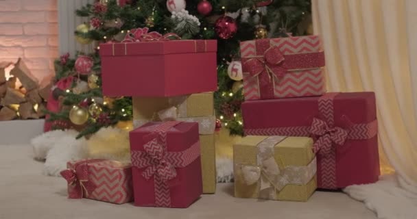 Gold Und Rotfarbene Geschenkboxen Der Nähe Des Weihnachtsbaums Zeitlupe — Stockvideo
