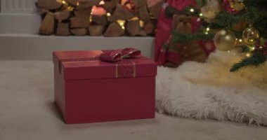 Kırmızı renkli Noel hediyesi kutusu yavaş çekimde açılıyor.