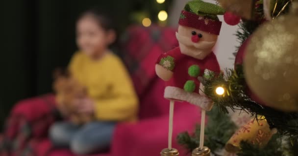 Santa Toy Hanging Christmas Tree Blurred Girl Wearing Yellow Playing — Vídeo de stock