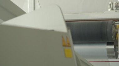 Closeup of polymer tape wending machine, slow motion