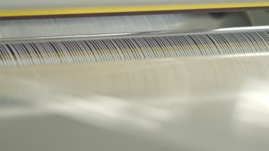 Closeup of polymer thread making machine in action, slow motion