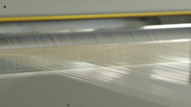 Closeup of polymer thread making machine in action, slow motion