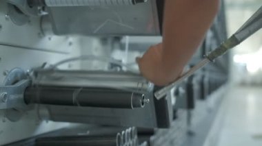 Operator works on polymer thread winding machine, slow motion