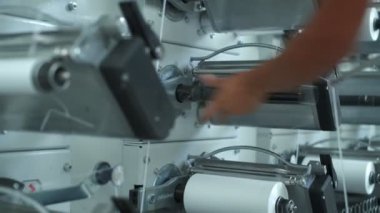 Operator works on polymer thread winding machine, slow motion