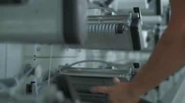 Operator works on polymer thread winding machine, slow motion