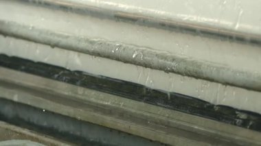 Closeup of Watering the polymer tape in winding machine, slow motion