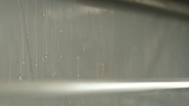 Closeup of Watering the polymer tape in winding machine, slow motion