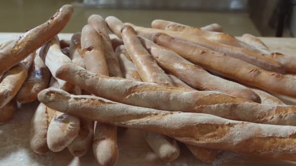 Φρέσκα Ψημένα Ψωμιά Μακριάς Μπαγκέτας Βρίσκονται Στο Ξύλινο Τραπέζι Πασπαλισμένα — Αρχείο Βίντεο