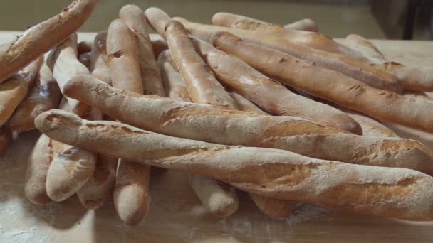 Φρέσκα Ψημένα Ψωμιά Μακριάς Μπαγκέτας Βρίσκονται Στο Ξύλινο Τραπέζι Πασπαλισμένα — Αρχείο Βίντεο