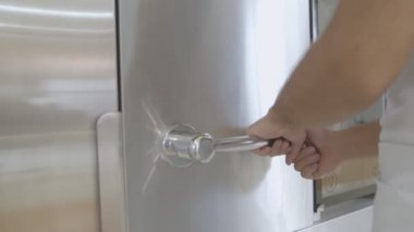 Fırıncıların elleri, büyük bir fırının kolunu ve metal kapısını çevirir ve el arabasında fırın tepsileriyle taze pişmiş ekmek görürüz...