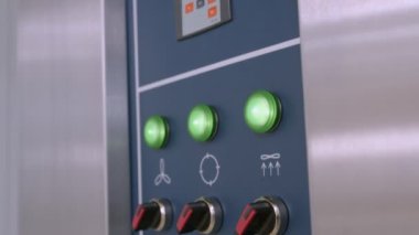Endüstriyel ekmek fırını kontrol panelinin, düğmeleri, ekranları ve fırçalanmış alüminyum görünümlü, yavaş çekim