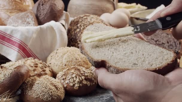 Мужские Руки Маслом Кусок Свежеиспеченного Голландского Хлеба Над Деревянным Столом — стоковое видео