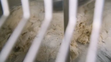 Hamuru karıştırırken beyaz ızgaranın içinden çalışan mikserin yakın plan görüntüsü. Yavaş çekim