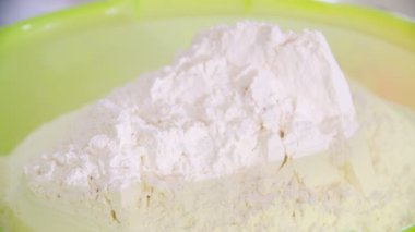 Pouring flour on a plastic tray in the bread factory