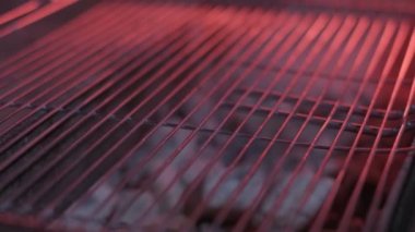 Close-up of raw big stake put on the already cooled grill. Filmed under the red light