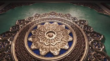 Dining room with richly colored walls and ceiling with Arabic-oriental patterns. Main color theme is gold with shades of green and blue colors