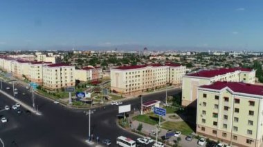 A panorama of a residential area of Tashkent shoot from a drone on the afternoon. There are blocks with high-rise buildings, private houses and streets with car traffic in the frame