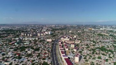 A panorama of a residential area of Tashkent shoot from a drone on the afternoon. There are blocks with high-rise buildings, private houses and streets with car traffic in the frame