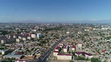 A panorama of a residential area of Tashkent shoot from a drone on the afternoon. There are blocks with high-rise buildings, private houses and streets with car traffic in the frame