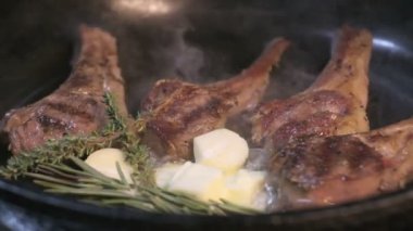 Small onions are thrown to the cast iron pan with lamb ribs fried in butter. Slow motion
