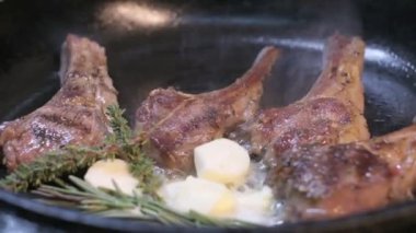 Small onions are thrown to the cast iron pan with lamb ribs fried in butter. Slow motion