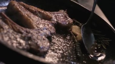 Small onions are thrown to the cast iron pan with lamb ribs fried in butter. Slow motion