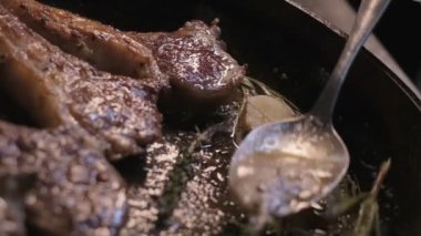 Small onions are thrown to the cast iron pan with lamb ribs fried in butter. Slow motion