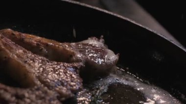 Small onions are thrown to the cast iron pan with lamb ribs fried in butter. Slow motion