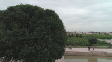 Drone camera flies over the pool in front of the mausoleum of memorial complex of Bahouddin Naqshband near Bukhara. Filmed on a cloudy day.