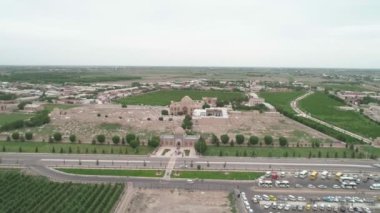Panorama of Bahouddin Naqshband memorial complex near Bukhara filmed by drone cam on a cloudy day. Green gardens, highway and parking zone are also in the frame