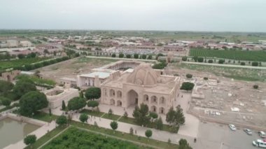 Memorial complex of Bahouddin Naqshband near Bukhara. Drone cam flies far above shooting the panorama contains higway, parking, memorial complex, nearby gardens then it rises higher. Filmed on a