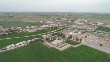 Memorial complex of Bahouddin Naqshband near Bukhara. Drone cam flies far above shooting the panorama contains higway, parking, memorial complex, nearby gardens then it rises higher. Filmed on a