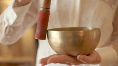 Young woman meditates doing yoga with Singing Bowl. Close-up