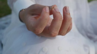Young woman meditating doing yoga in the park on a sunny day, slow motion, close-up