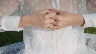 Young woman meditating doing yoga in the park on a sunny day, slow motion, close-up
